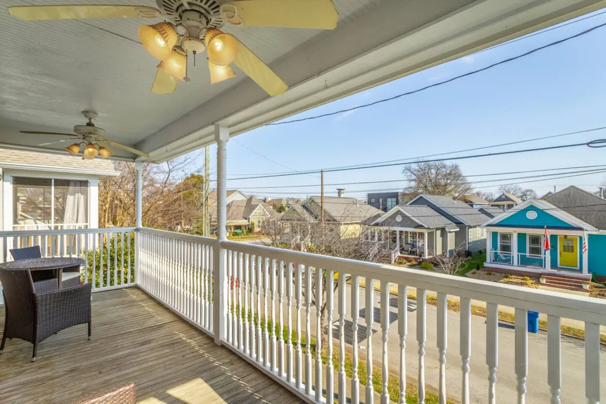 This image highlights a cozy exterior patio with stylish furniture and a ceiling fan, offering a view onto the street. It suggests opportunities for families to socialize, enjoy the neighborhood, or simply watch the world go by.